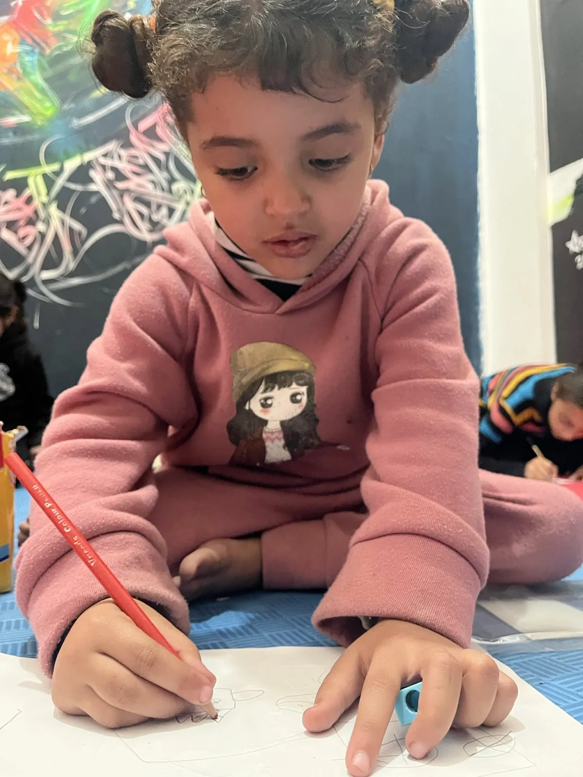 Young child focused on drawing during the Colors of Hope therapy program