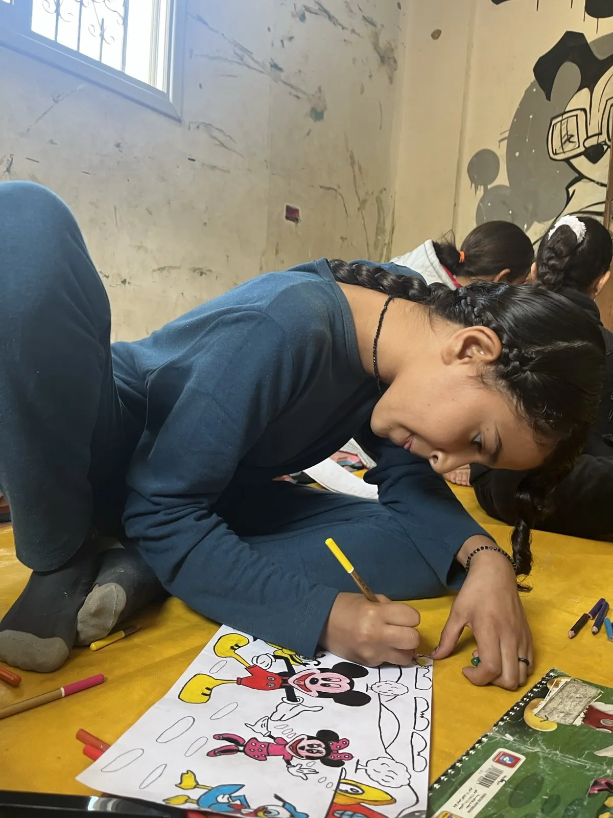 Student carefully coloring her artwork during art therapy